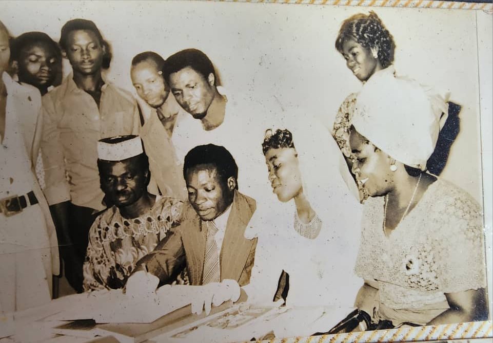Signing the wedding register surrounded by family and friends