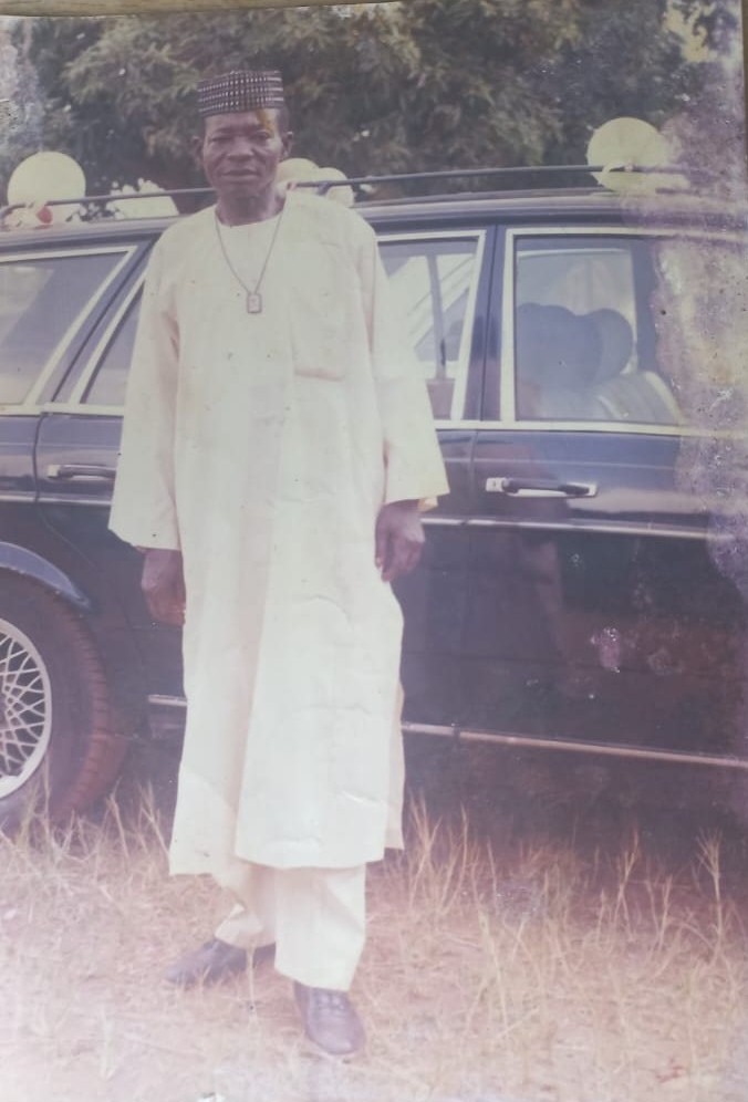Pa. Ogunor standing beside a car in his younger years